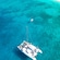 An aerial view of a catamaran anchored near a beach